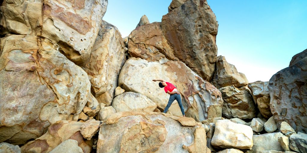 a man climbing up the side of a large rock