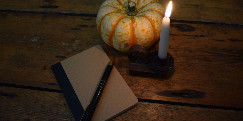 a candle and a notebook on a wooden table