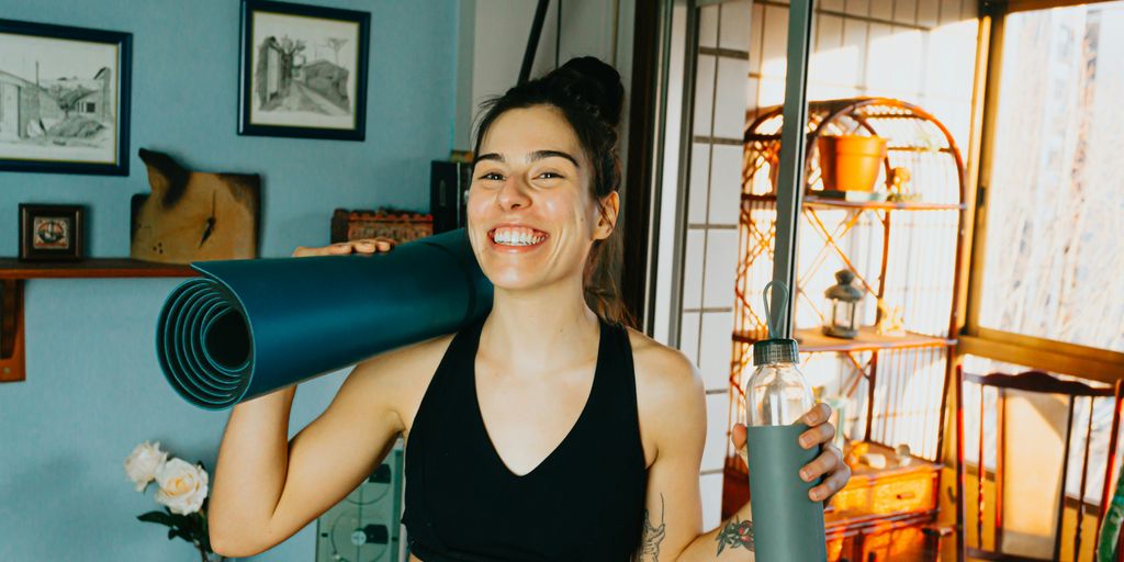 woman in black sports bra holding blue and black kettle