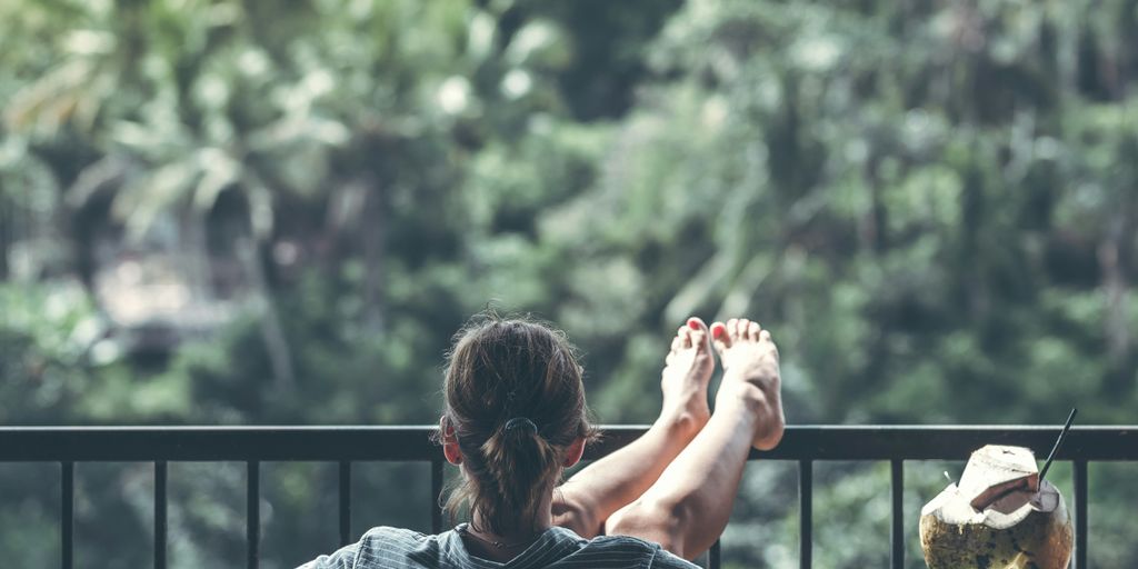 person sitting on chair in front of tree
