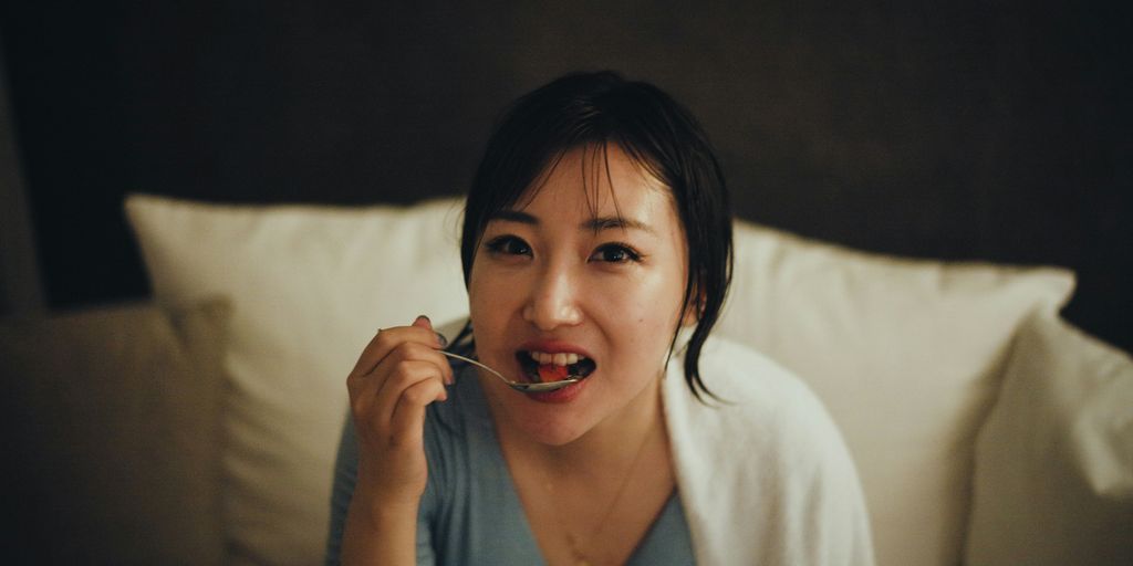 a person sitting on a bed talking on the phone