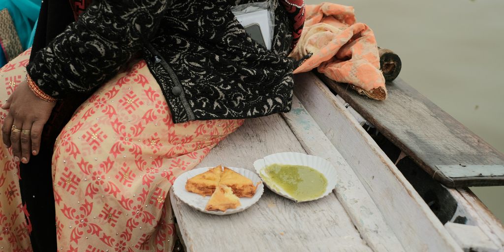 a woman sitting on a boat with a plate of food