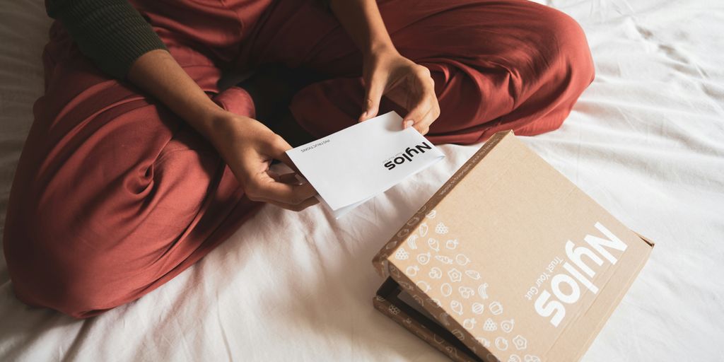person holding white book on bed