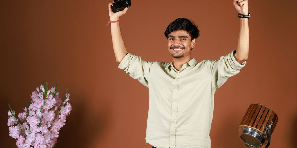 a man holding up two cell phones in the air