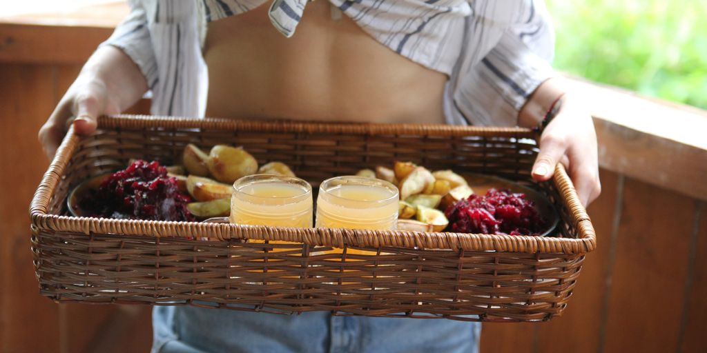 person standing and carrying basket with juice and pastry