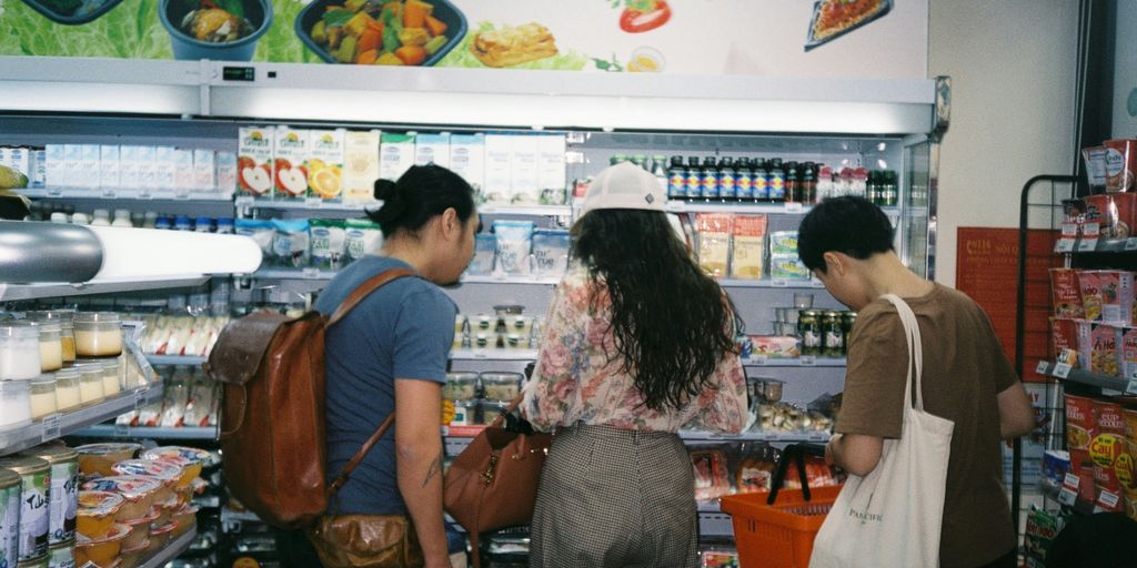 woman in brown long sleeve shirt and gray pants standing in front of white counter