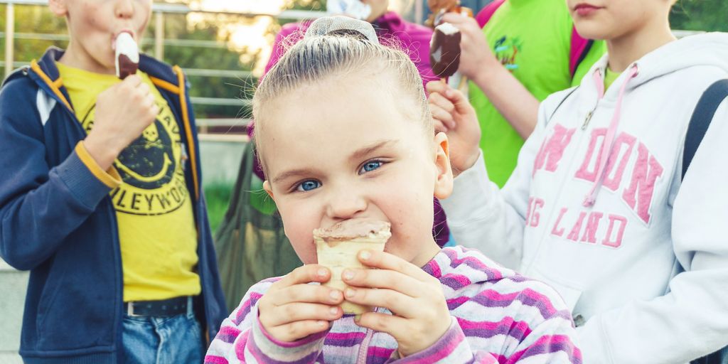 boy in white and pink striped long sleeve shirt holding ice cream