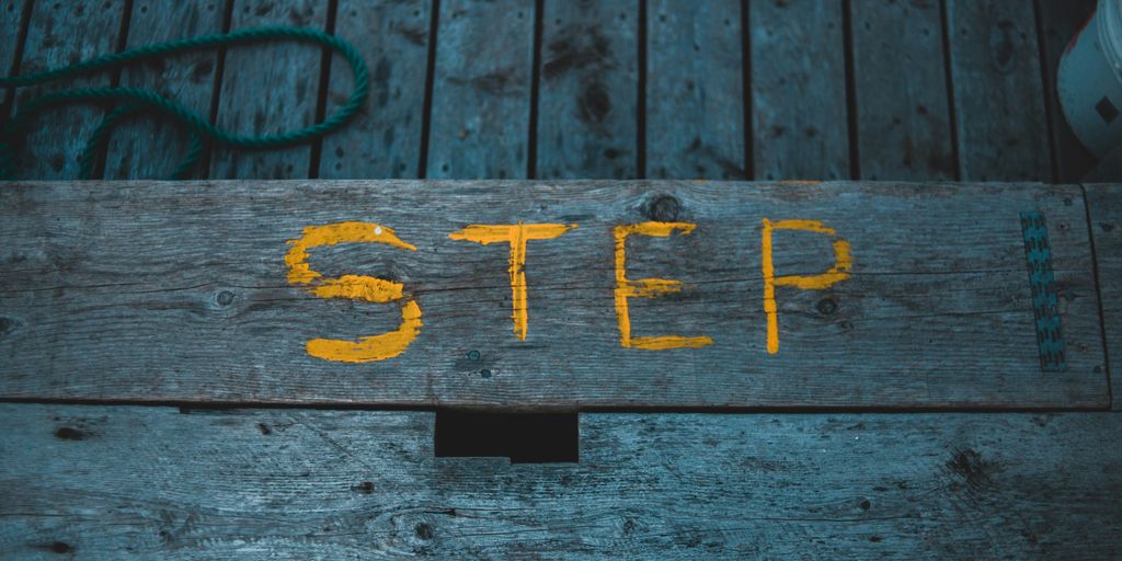 a wooden step with a yellow step painted on it