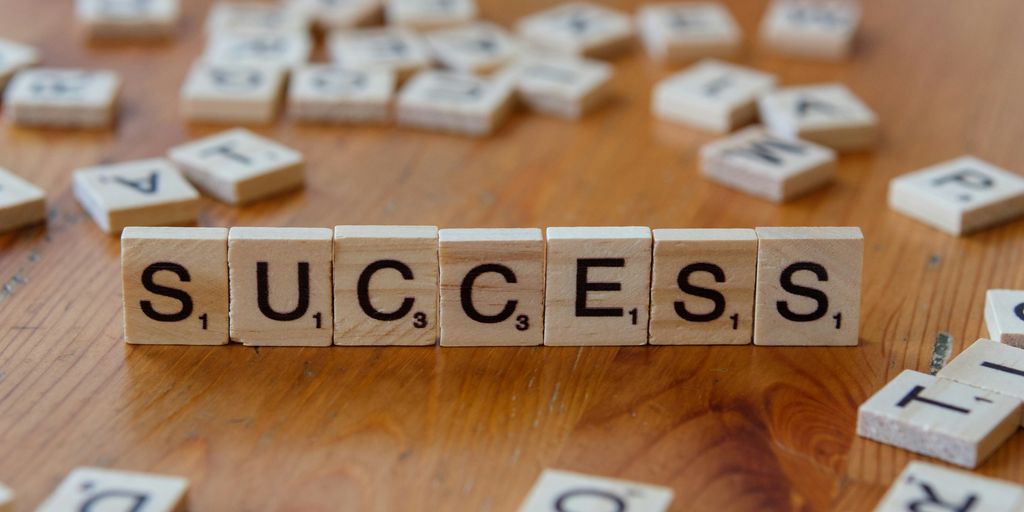 Scrabble tiles spelling out the word success on a wooden table