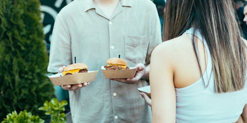 a man and a woman holding sandwiches in their hands
