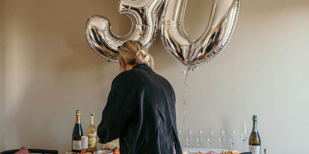 a person standing in front of a table with food and wine bottles