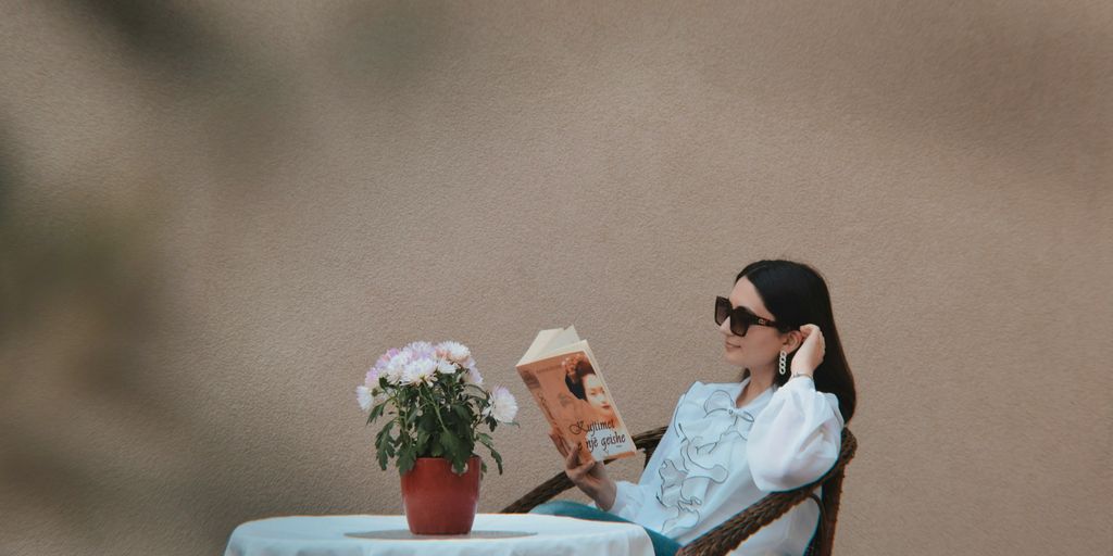 a person sitting at a table reading a book