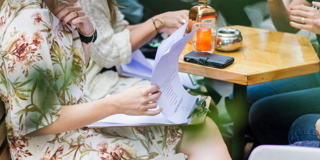 woman smiling while flipping page of papers on a clipboard