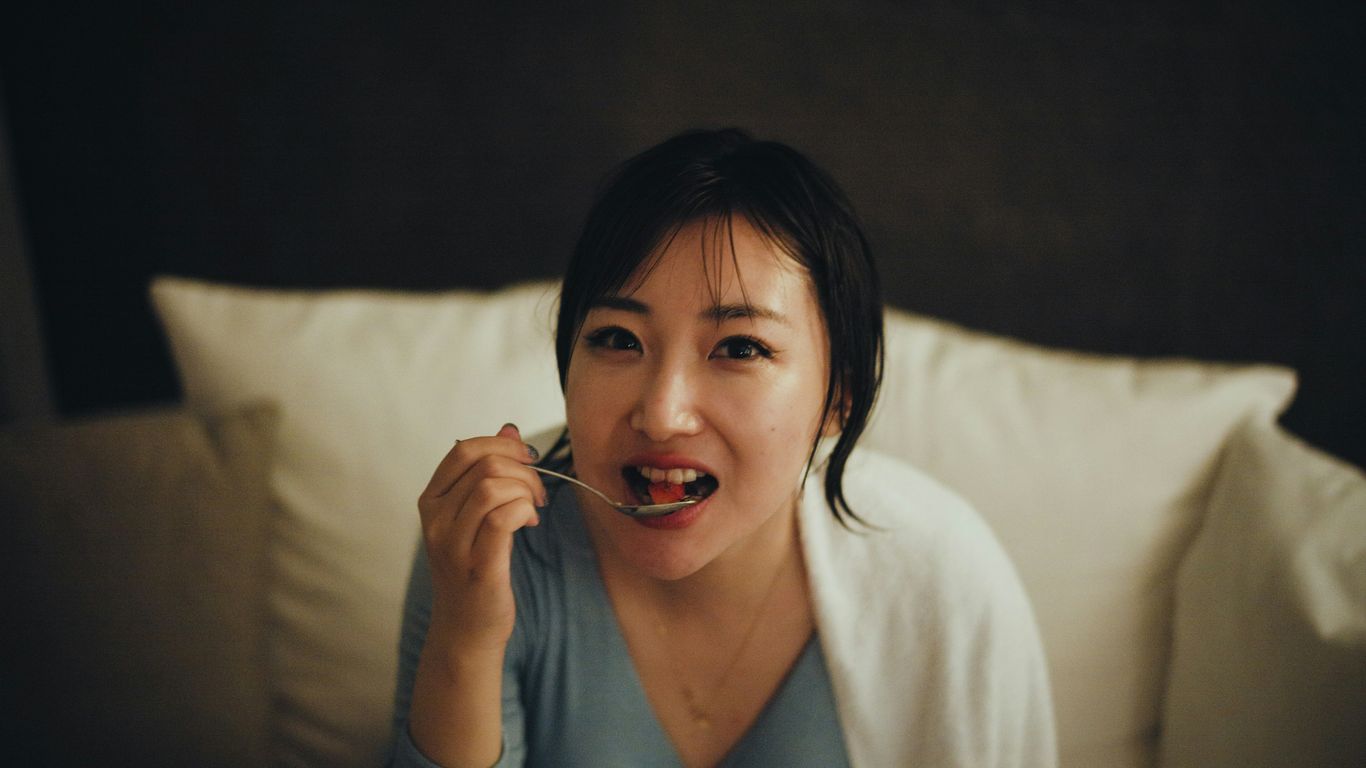 a person sitting on a bed talking on the phone