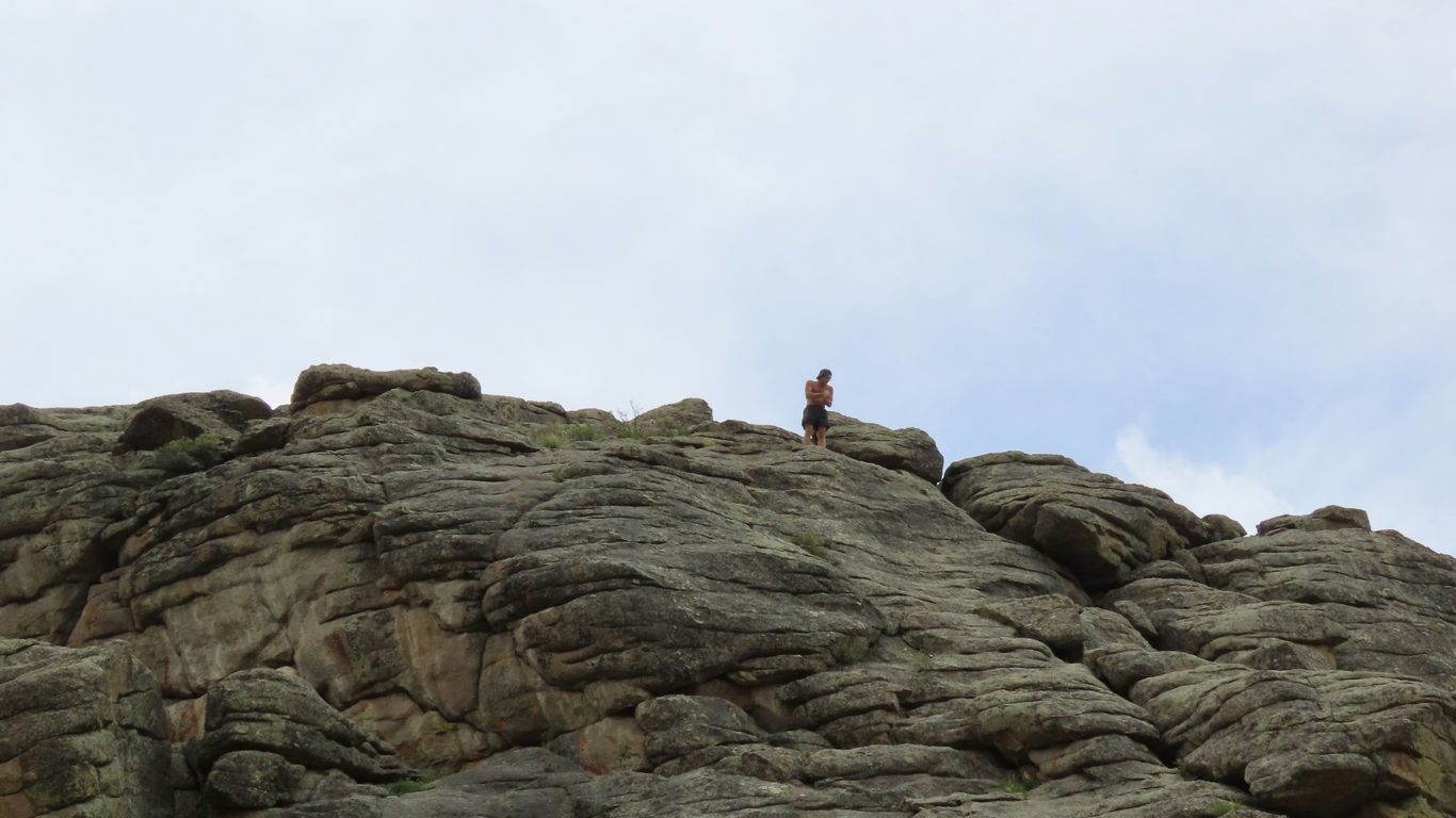 a person standing on top of a large rock