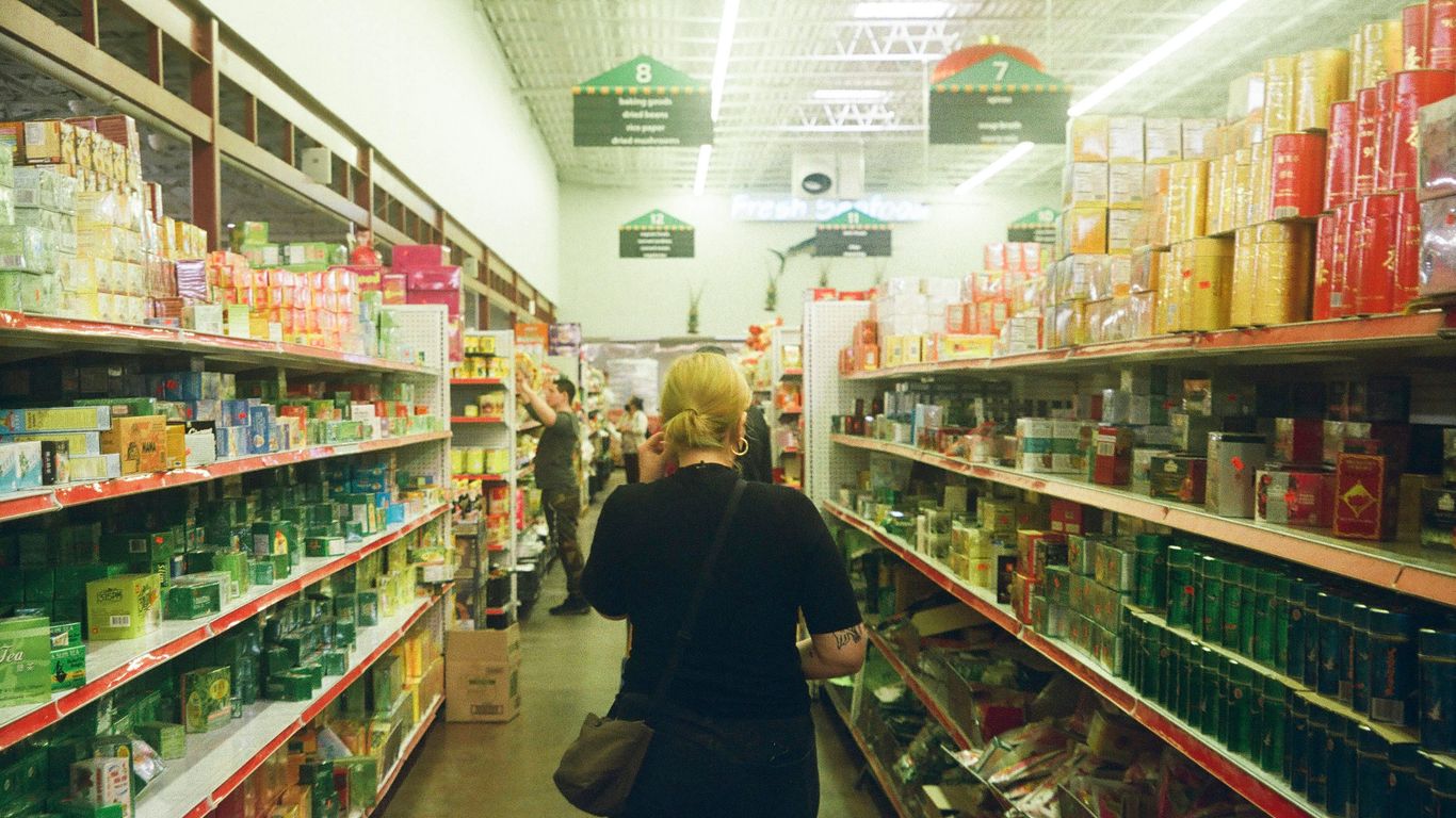 woman in black long sleeve shirt standing near white shelf