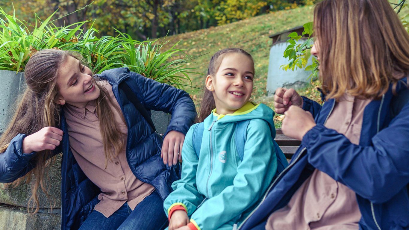 a group of women sitting next to each other on a bench
