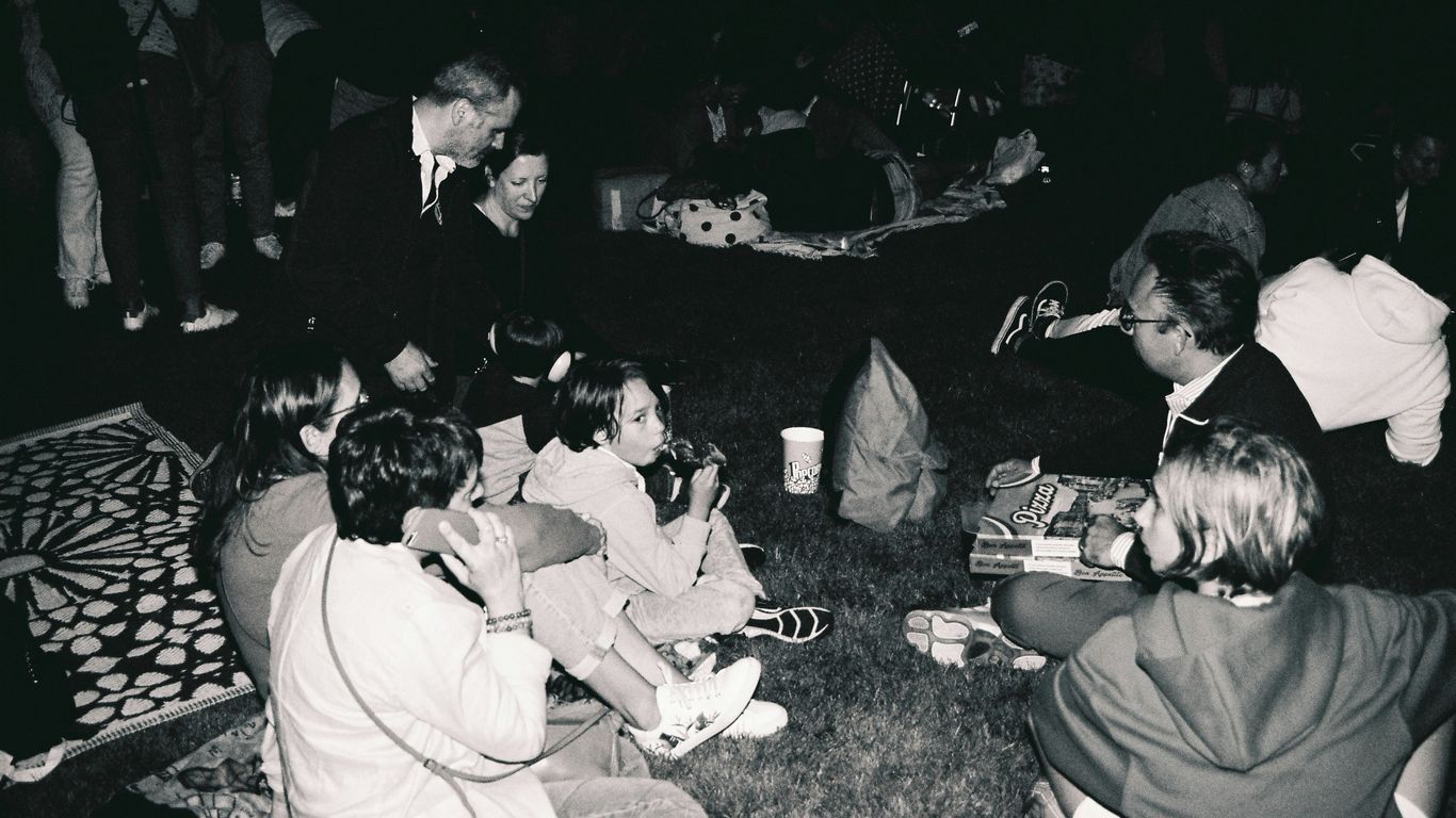 a group of people sitting on the ground eating food