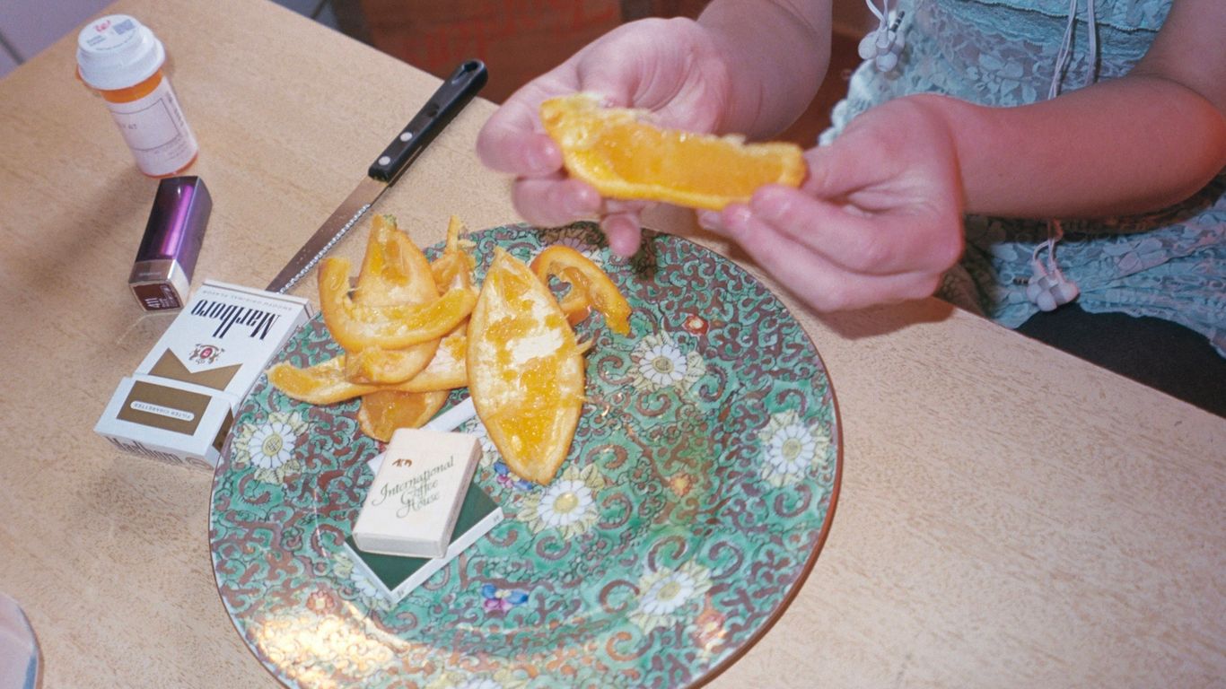 a person is peeling an orange on a plate