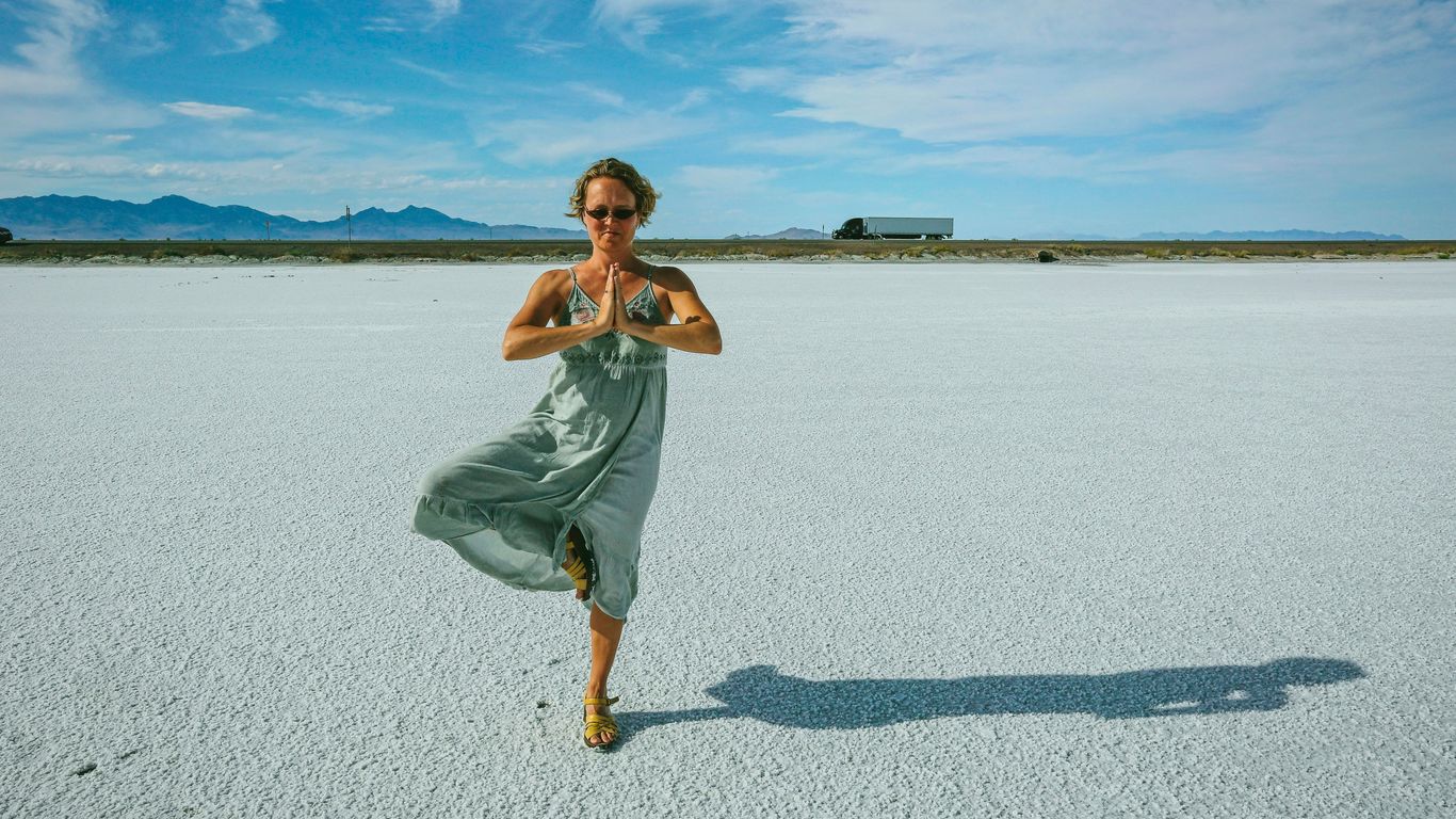 a woman standing in the middle of a desert