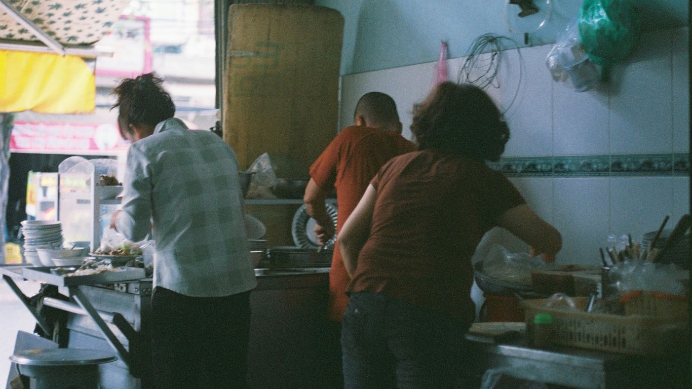 a group of people in a kitchen preparing food