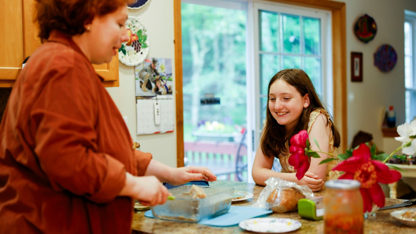 Woman preparing food with a girl watching