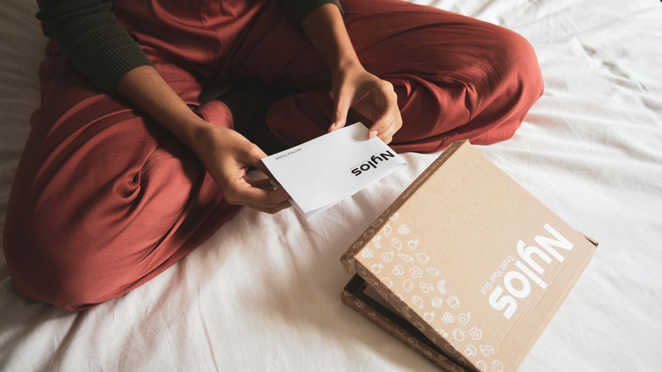 person holding white book on bed