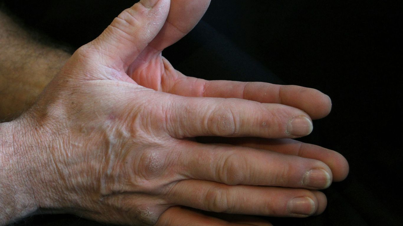 a person's hands with a black background