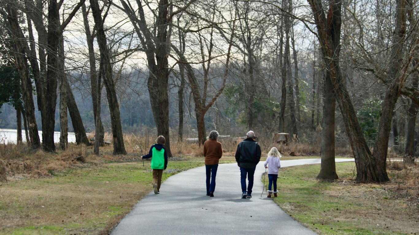 a group of people walking down a path in a park