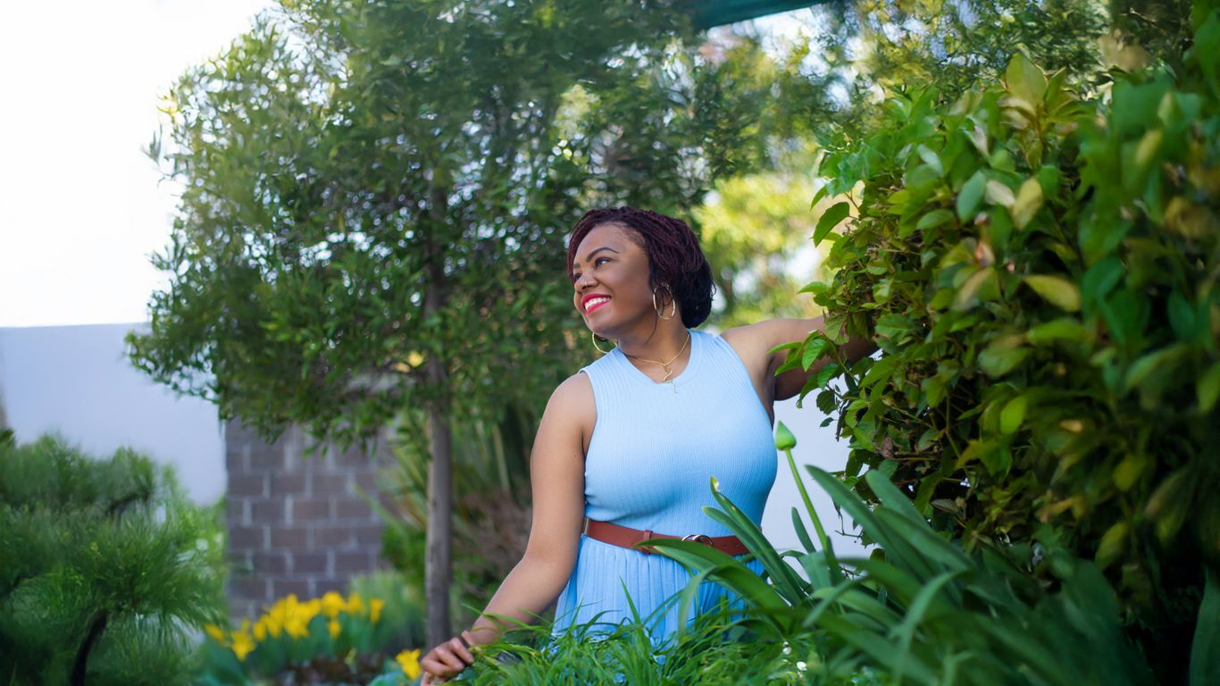 A woman in a blue dress standing in a garden