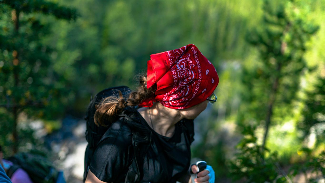 A woman in a red bandana is riding a bike