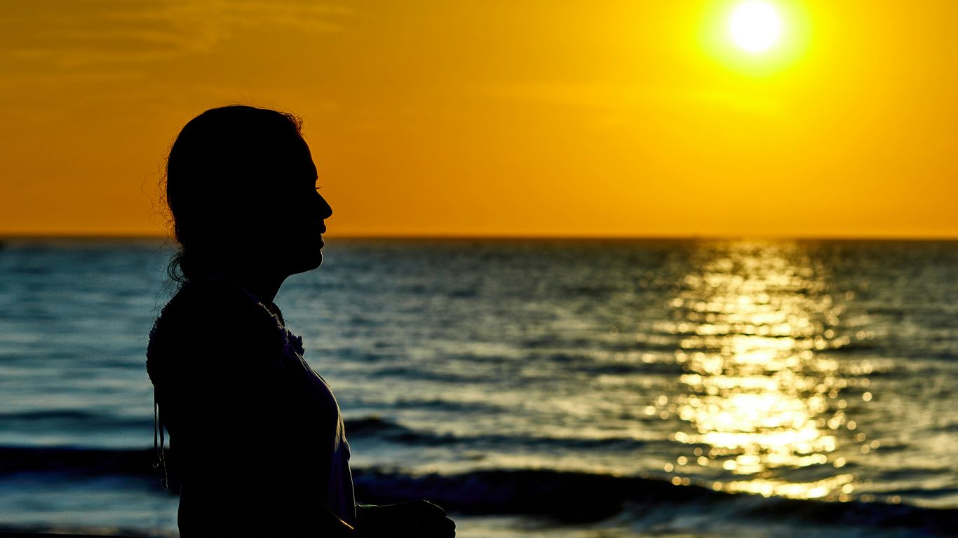 woman standing infront of beach during sunset