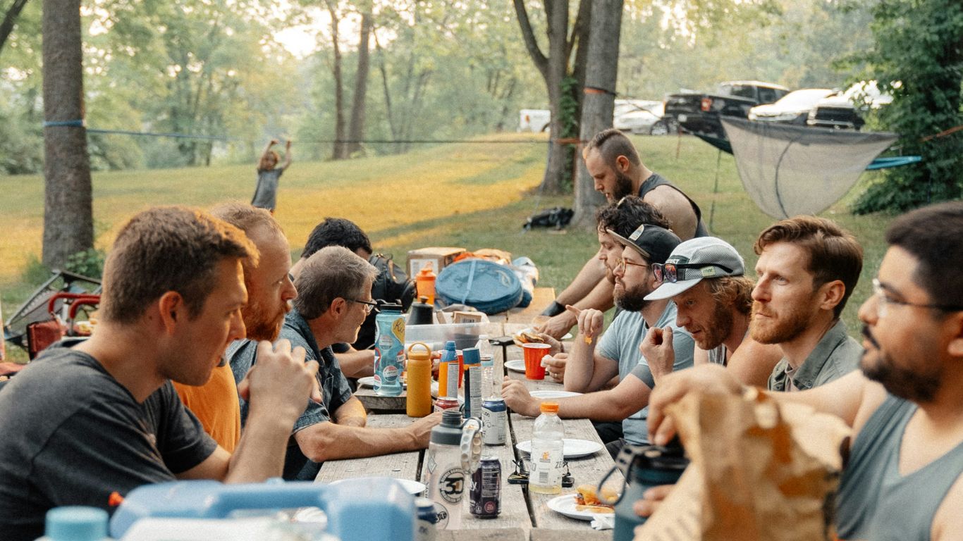a group of people sitting around a picnic table