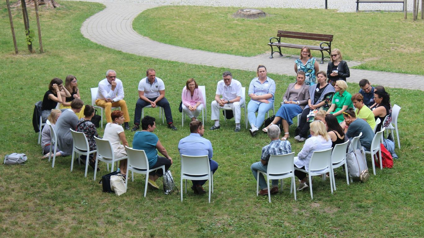 circle of people sitting on chair on grass fiedl
