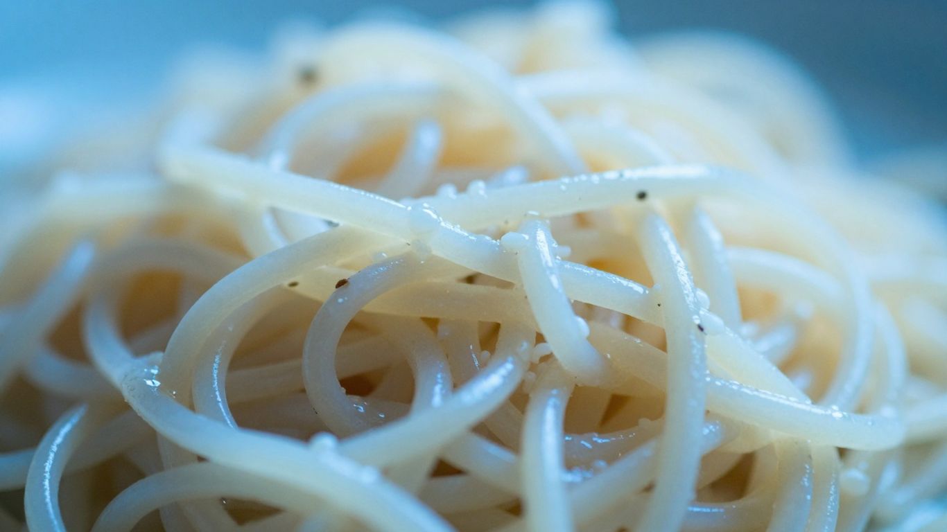 Cooked pasta strands with a cool, translucent appearance.